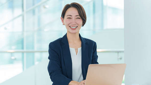 笑顔の女性がノートパソコンを操作している様子