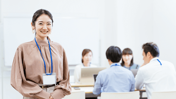 職場で働く女性と打ち合わせをするチーム